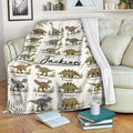 Dinosaur alphabet blanket draped over a sofa with illustrated prehistoric creatures and leafy accents