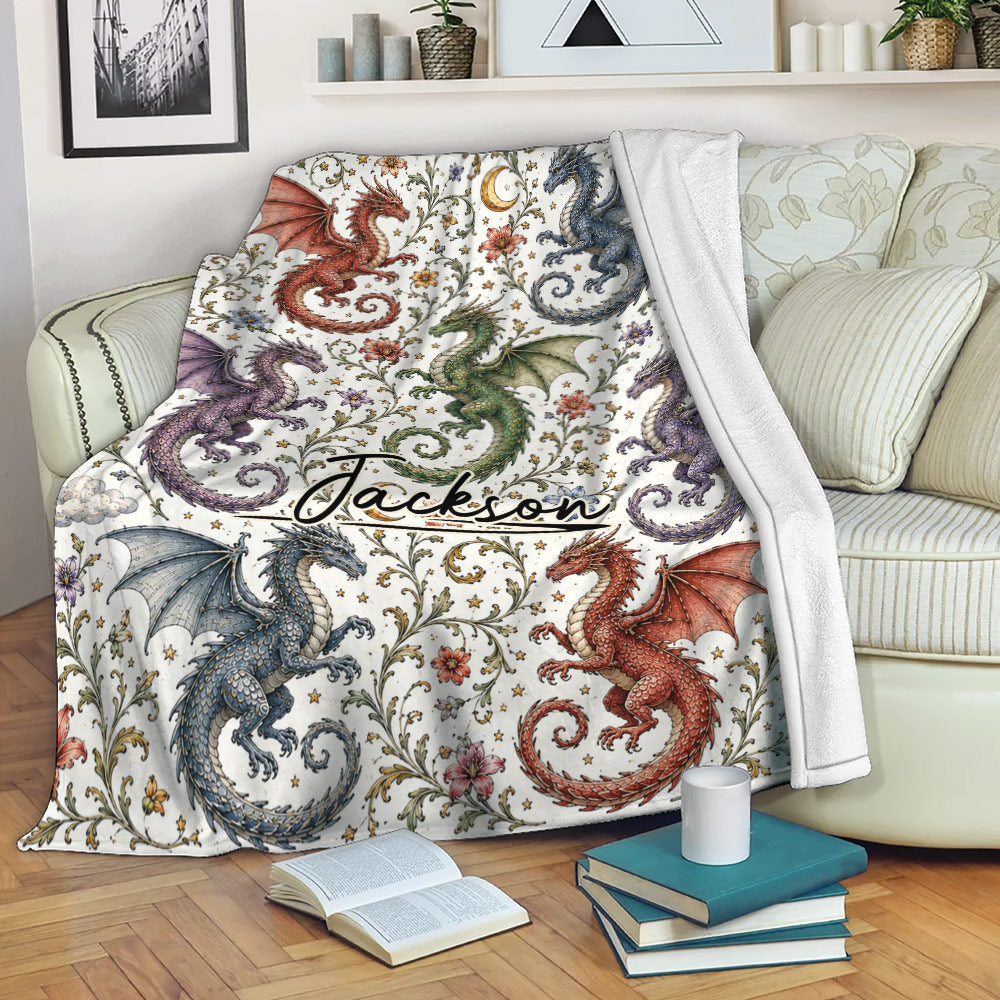 Colorful dragon throw blanket draped over a sofa, featuring winged dragons, flowers, stars, and a crescent moon