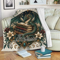 Dragon throw blanket draped over a sofa with fantasy book artwork, flowers, stars, and decorative borders