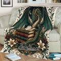 Fantasy dragon blanket displayed on a sofa with an open book, stacked books, florals, and celestial artwork