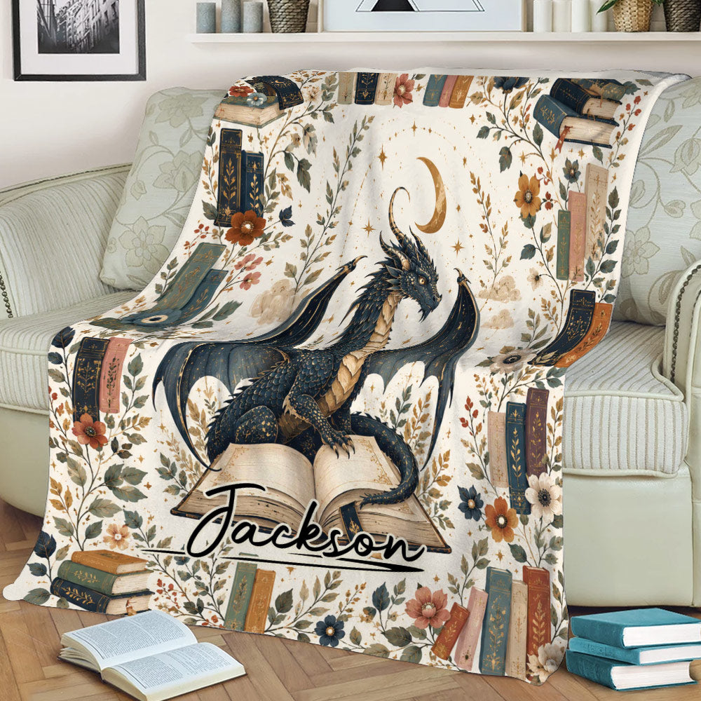 Fantasy dragon blanket displayed on a couch with open books, botanical accents, and vintage book artwork
