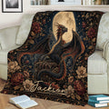 Close view of a dragon throw blanket featuring wings, a full moon, flowers, and dark fantasy artwork