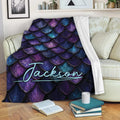Dragon scale blanket draped over a sofa with vivid purple and blue fantasy artwork
