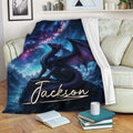Cosmic dragon blanket draped over a sofa with vivid blue, purple and pink fantasy artwork