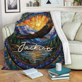 Eagle blanket displayed on a sofa with colorful stained glass mountain and woodland artwork