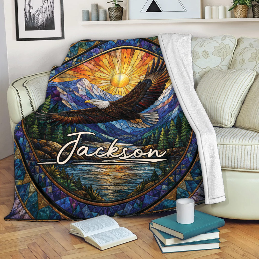 Eagle blanket displayed on a sofa with colorful stained glass mountain and woodland artwork