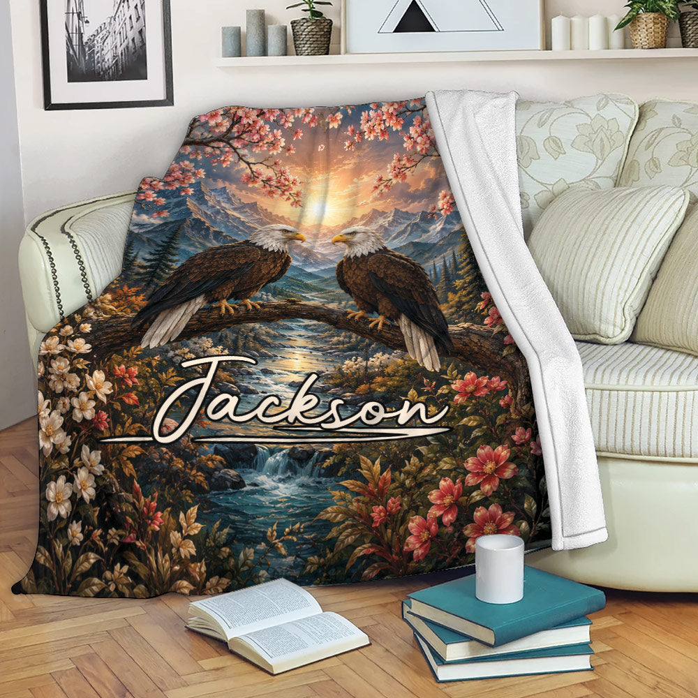 Eagle blanket draped over a sofa with mountain wildlife artwork, river scenery, and colorful floral branches