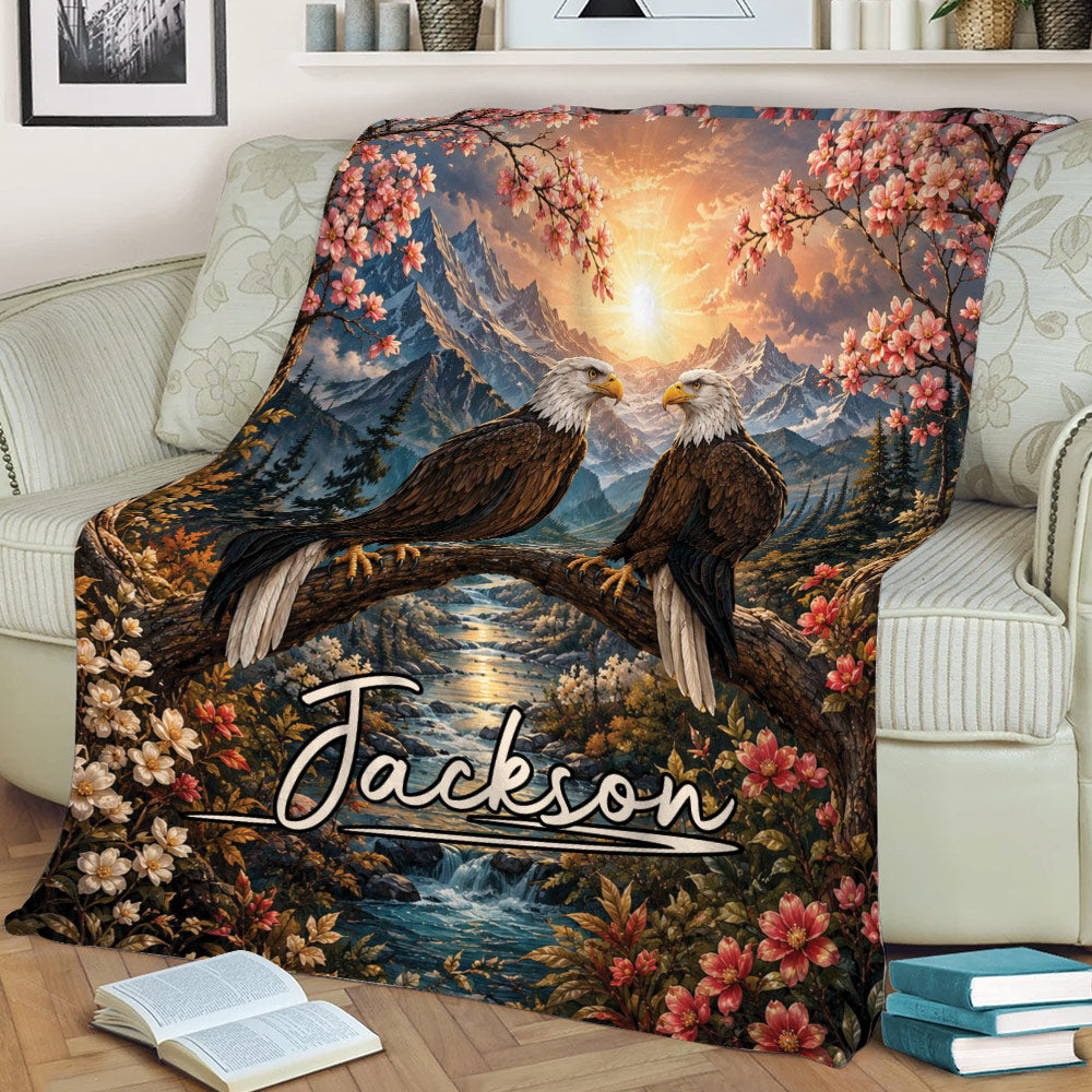 Eagle throw blanket displayed on a sofa with two perched eagles, mountains, a river, and floral scenery