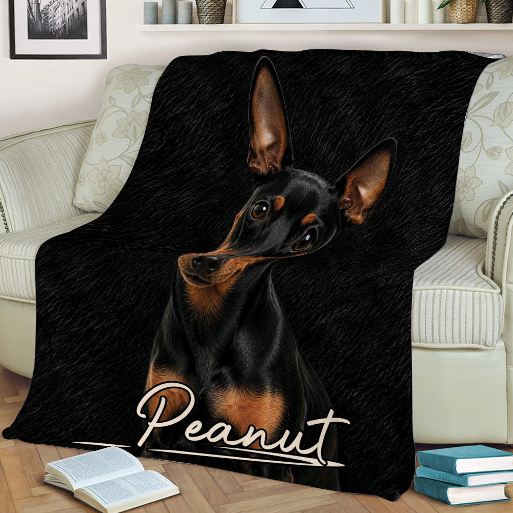 Miniature Pinscher dog artwork displayed on a throw blanket across a sofa