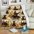 Miniature Pinscher blanket displayed on a sofa with sunflower artwork and black and tan dog portraits