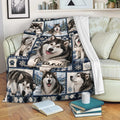 Alaskan Malamute throw blanket displayed on a sofa with snowy dog artwork and cozy living room styling