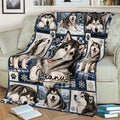 Alaskan Malamute blanket draped across a couch with detailed dog portraits, snowflakes, and mountain scenes