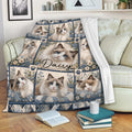 Ragdoll cat blanket draped over a sofa, featuring blue-eyed cats, flowers, and cozy blue decorative details