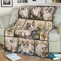 Floral Ragdoll cat throw blanket displayed on a sofa with multiple blue-eyed cat panels and daisy artwork
