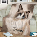 Blue-eyed Ragdoll cat throw blanket styled across a sofa with books nearby