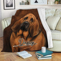 Bloodhound blanket draped over a sofa with realistic brown dog artwork and cozy reading decor
