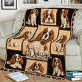 Cavalier King Charles Spaniel blanket spread across a sofa with detailed dog artwork and decorative border