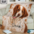 Close view of a Brittany Spaniel throw blanket styled on a sofa with warm dog artwork
