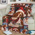 Festive Brittany Spaniel blanket spread across a sofa with Santa hats, scarves, snow, and plaid