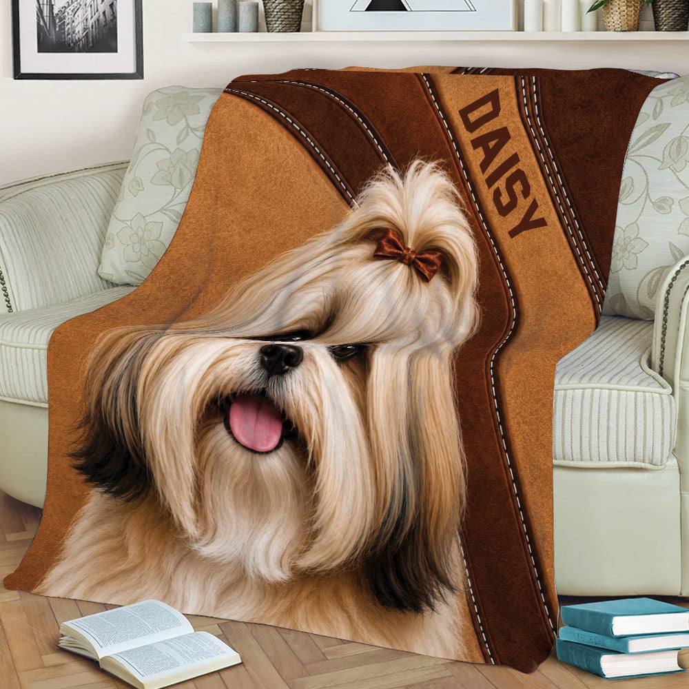 Close view of a Lhasa Apso dog design on a brown throw blanket displayed across a sofa