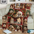 Close view of a Lhasa Apso Christmas blanket draped over a sofa with Santa hats, scarves, and gift-themed artwork