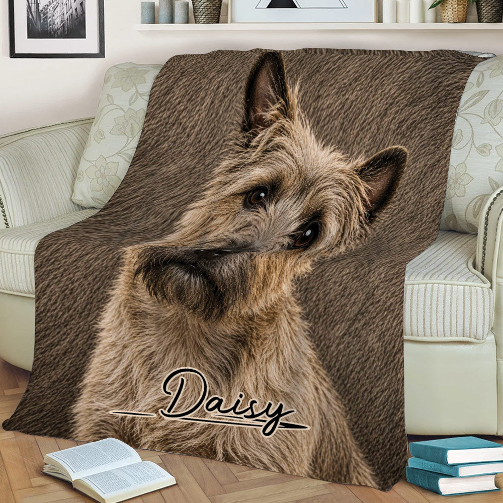 Cairn Terrier throw blanket draped across a sofa, showcasing detailed dog artwork and warm brown tones