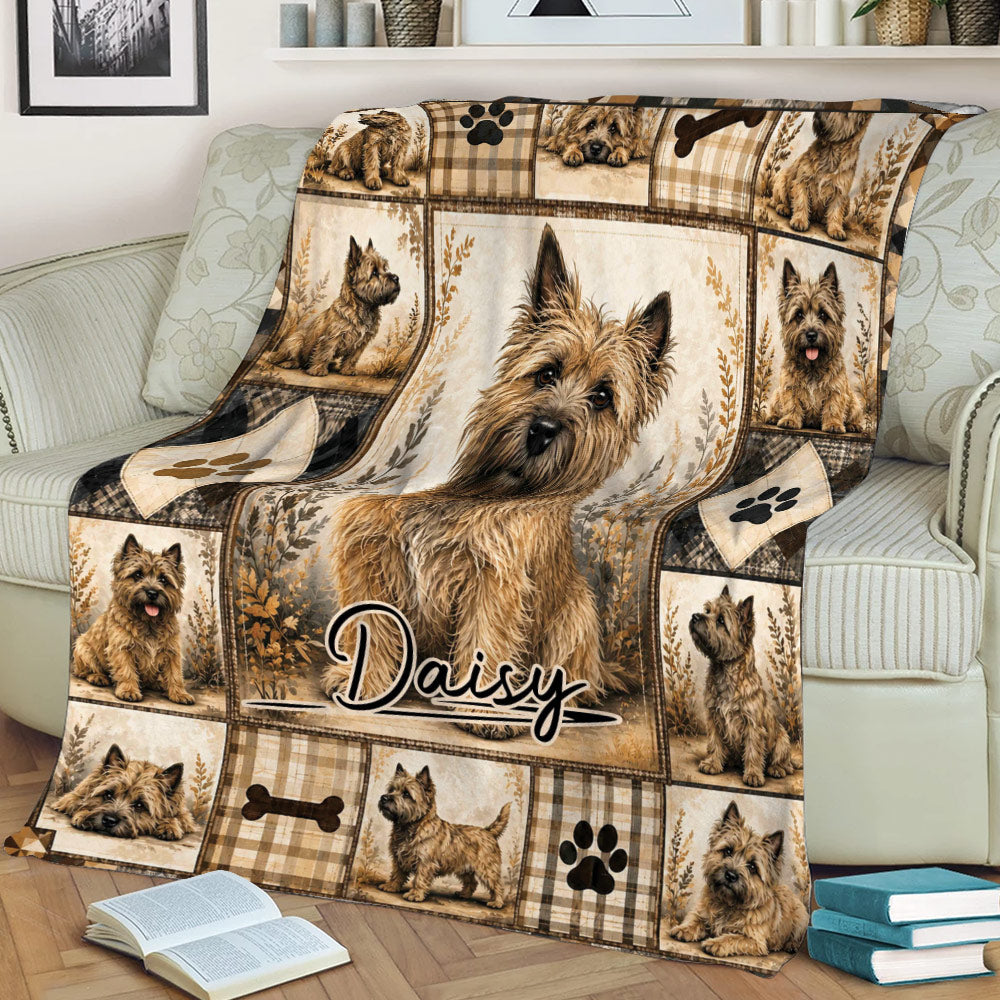 Close view of Cairn Terrier throw blanket on a sofa featuring a central dog portrait and plaid border