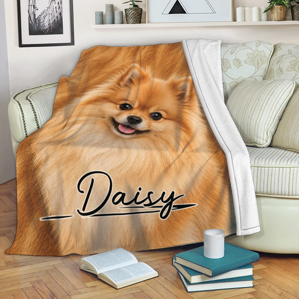 Pomeranian throw blanket draped over a sofa, showing a cheerful orange dog design