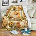 Pomeranian blanket draped over a sofa with sunflower artwork and multiple cheerful dog portraits