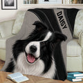Close view of a Border Collie throw blanket styled on a sofa with books nearby