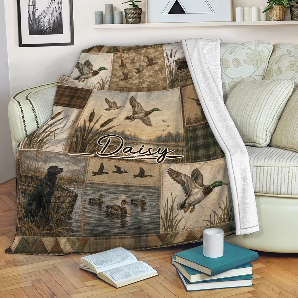 Duck hunting throw blanket displayed on a sofa with mallards, marsh scenes, a retriever, and rustic outdoor artwork