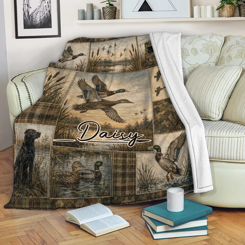 Duck hunting blanket displayed on a sofa with mallard artwork, wetlands, reeds, and rustic camouflage panels