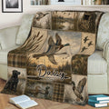 Waterfowl hunting throw blanket draped over a couch with flying ducks, marsh artwork, reeds, and a hunting dog