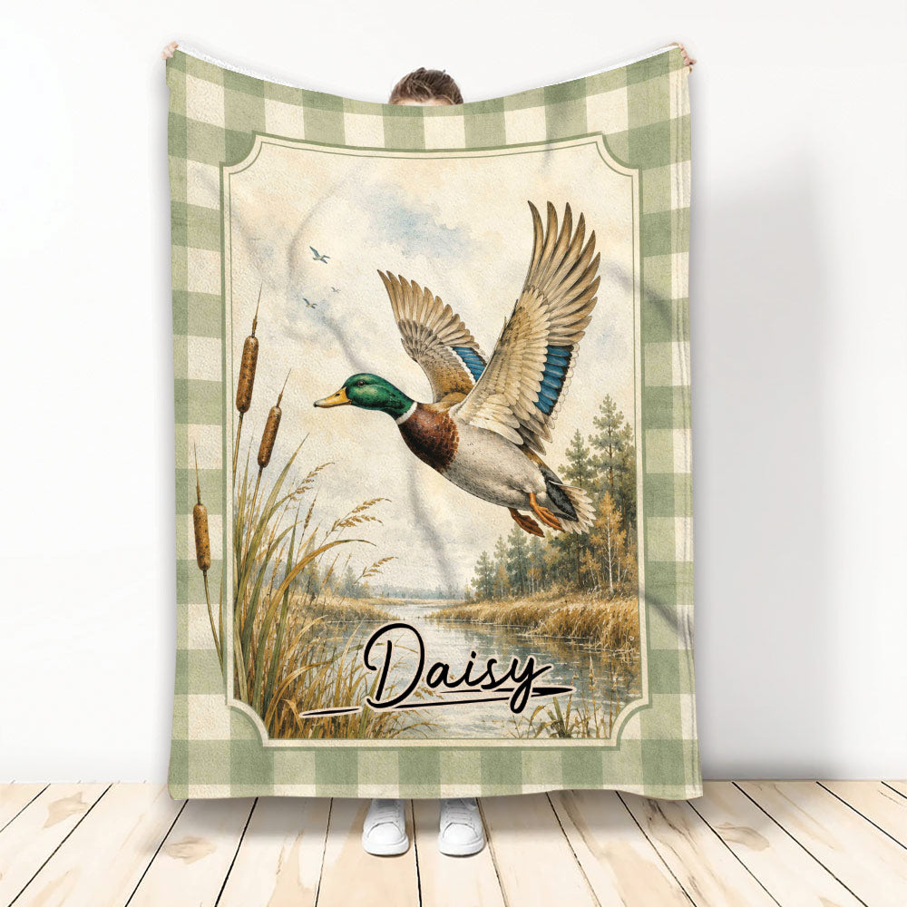Duck hunting blanket featuring a flying mallard over a marsh scene with cattails and a green plaid border