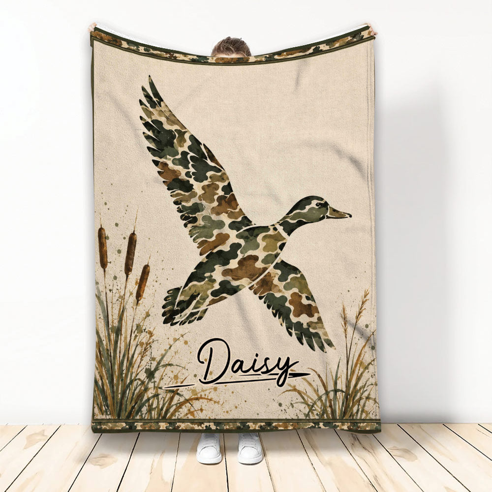 Duck hunting blanket featuring a flying camouflage duck, cattails, marsh grasses, and rustic outdoor artwork