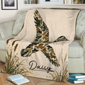 Close view of a duck hunting blanket with a flying waterfowl design, marsh grasses, and rustic camouflage colors