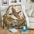 Custom duck hunting throw blanket displayed on a sofa with flying mallard and marsh artwork
