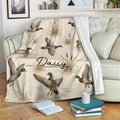 Duck hunting throw blanket displayed on a sofa with mallard ducks and wetland artwork