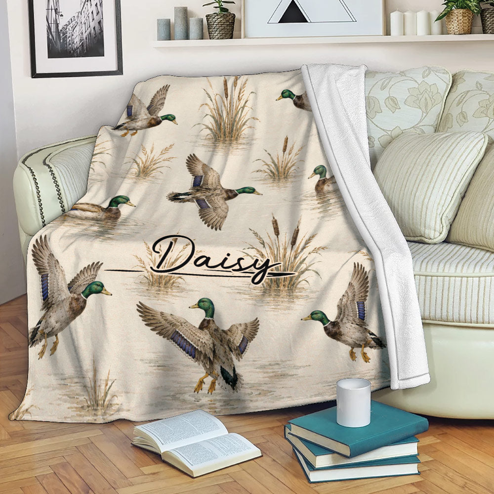 Duck hunting throw blanket displayed on a sofa with mallard ducks and wetland artwork