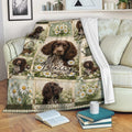 Boykin Spaniel blanket draped over a sofa with floral dog artwork and cozy reading decor