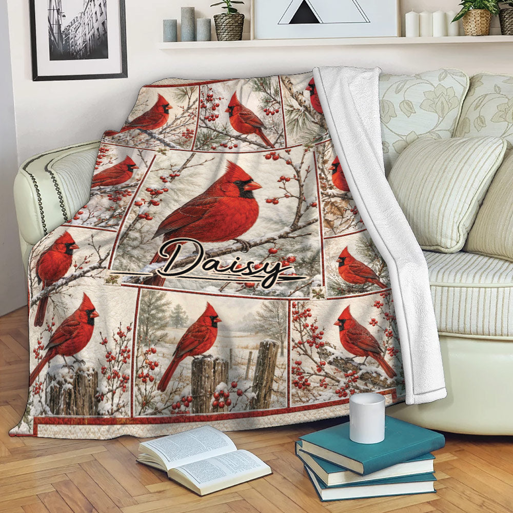 Cardinal throw blanket draped over a sofa with red birds, snowy branches, and berry accents