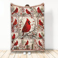 Cardinal throw blanket with red birds, winter branches, berries, and a central bird design