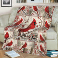Cardinal blanket displayed on a sofa with vivid red birds and winter woodland artwork