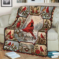 Red cardinal blanket draped over a sofa with winter branches, pinecones, poinsettias, and birdhouse artwork