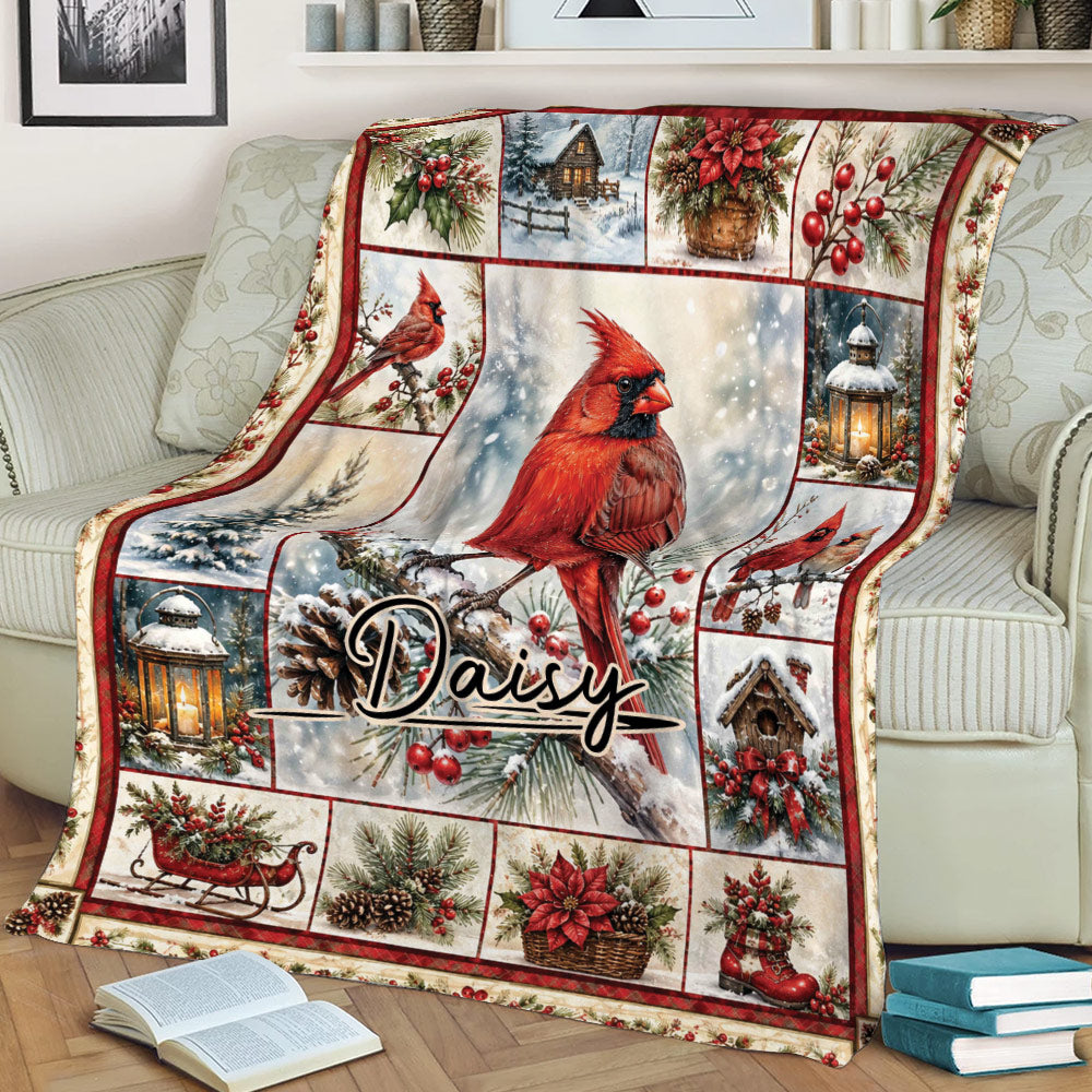 Red cardinal Christmas blanket draped over a couch with snowy branches, poinsettias, sleigh decor, and birdhouses
