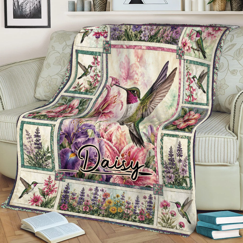 Floral hummingbird throw blanket displayed on a sofa with colorful flowers and botanical artwork