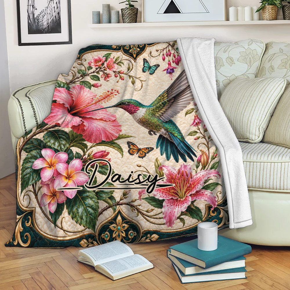 Hummingbird blanket draped over a sofa with tropical floral artwork in a cozy living room