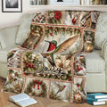Close lifestyle view of a hummingbird throw blanket on a sofa with winter berries, ornaments, and lanterns