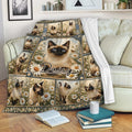 Siamese cat throw blanket draped over a sofa with floral artwork, butterflies, and a cozy reading setting