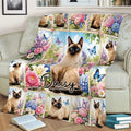 Floral Siamese cat blanket styled across a sofa, featuring blue-eyed cats, butterflies, and colorful flowers